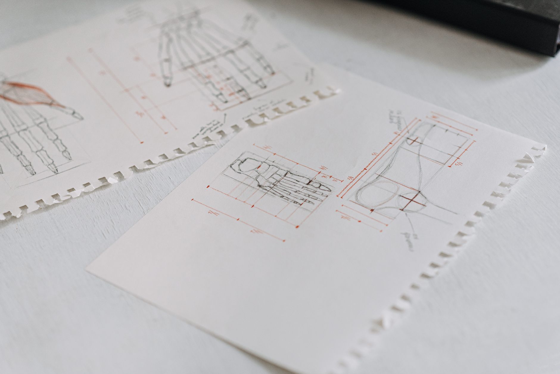 Gros plan de dessins techniques détaillés sur des feuilles de papier blanc soigneusement disposées, soulignant les concepts de conception.